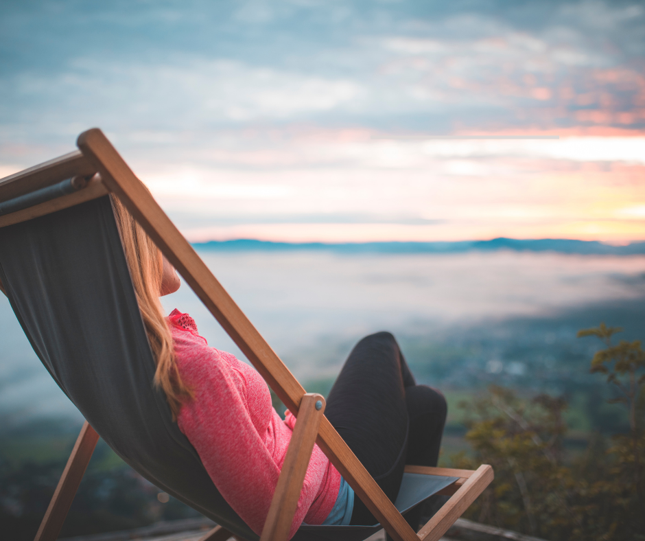 A person relaxing in a deck chair with a view of the sea, symbolizing full disconnection and recovery from work life.